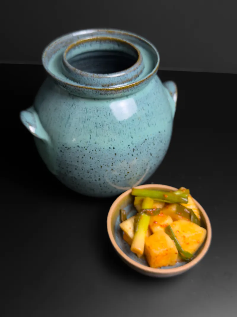 Turquoise jar beside a small bowl of kimchi