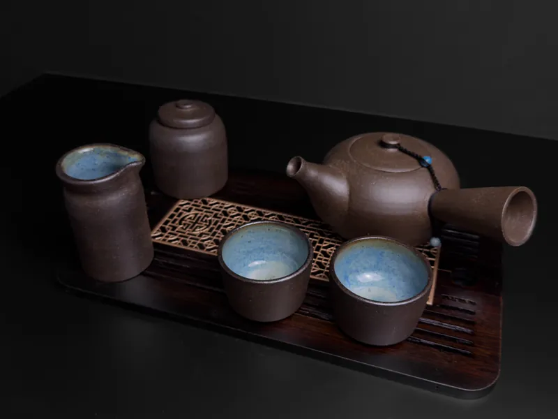 Brown clay tea set on a wooden tray: teapot, pitcher, caddy and cups