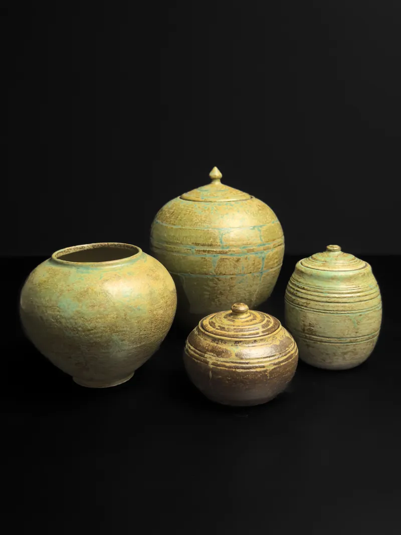 Four lidded jars in green and brown glazes